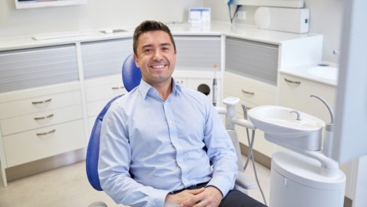 Smiling man sitting in dental chair
