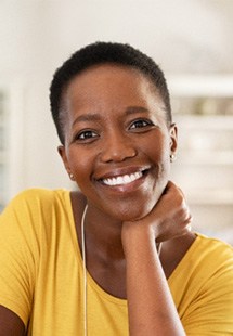 Woman in yellow shirt smiling at home