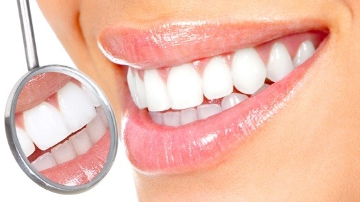 Close up of bright smile next to dental mirror