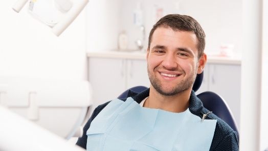 Smiling man in dental chair in Tulsa dental office