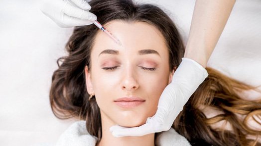 Woman having filler injected into her cheek