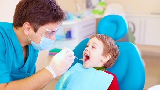 Dentist performing a dental exam on a young boy