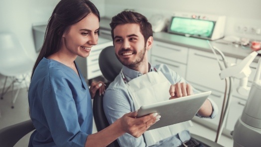 Dental team member showing a tablet to a patient