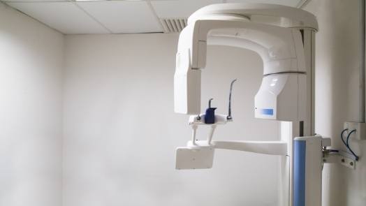 C T cone beam scanner against white wall of dental office