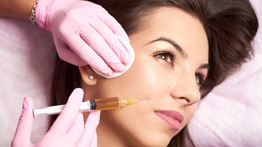 Woman having filler injected into her cheek