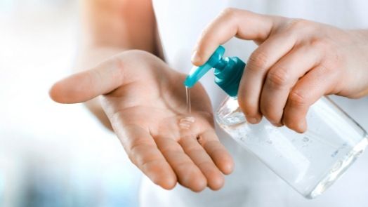 Person pouring hand sanitizer onto their hand