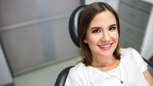 Smiling young woman in dental chair