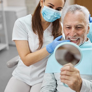 An older man admiring his new dental implants