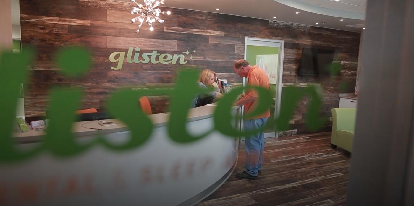 Man checking in at front desk of Glisten Dental Care of Tulsa