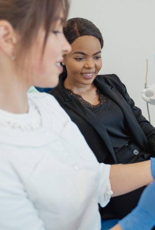 Dental team member showing a screen to a patient in dental chair