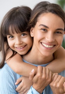 Mom and daughter smiling together