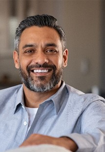 Mature man smiling on couch at home