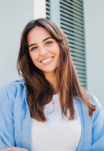 Woman with white teeth smiling while standing outside