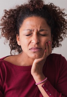 Woman with toothache sitting on couch at home