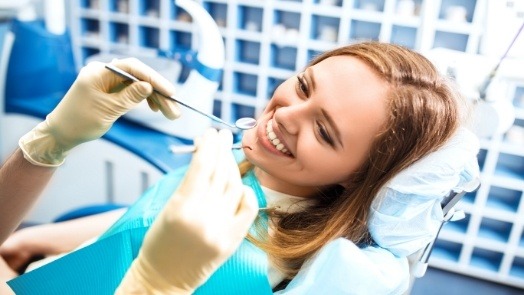 Woman smiling before receiving a teeth cleaning