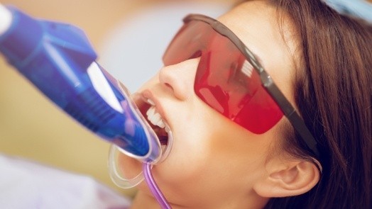 Young woman getting fluoride treatment in dental office