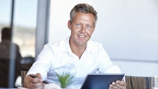 Man sitting at table with tablet