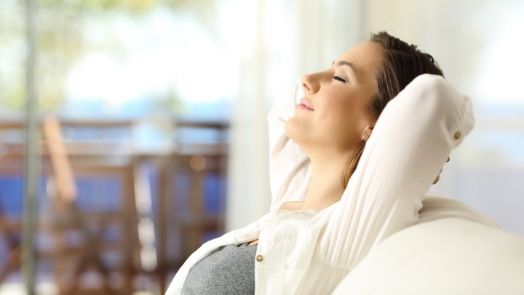 Smiling woman relaxing with hands behind head after sedation dentistry in Tulsa