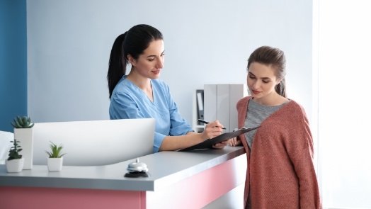 Dental team member showing clipboard to a patient