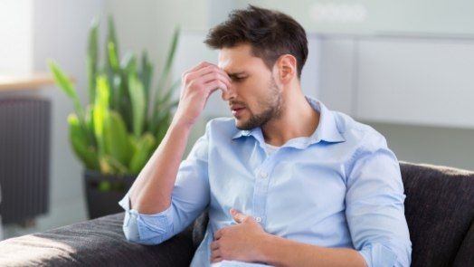 Man pinching the bridge of his nose in pain