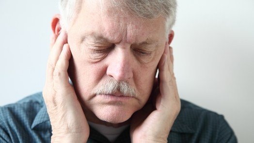 Older man touching his temples in pain