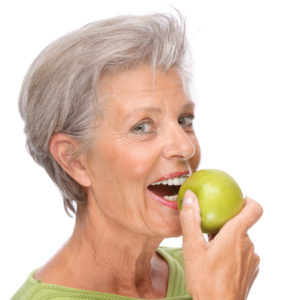 woman smiling preparing to eat apple