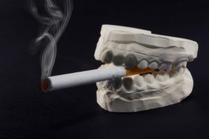 teeth mold holding a cigarette