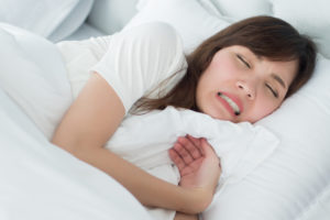 Stressed sleeping woman grinding teeth
