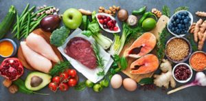 a spread of healthy foods including fish, lean meats, fruits, and vegetables