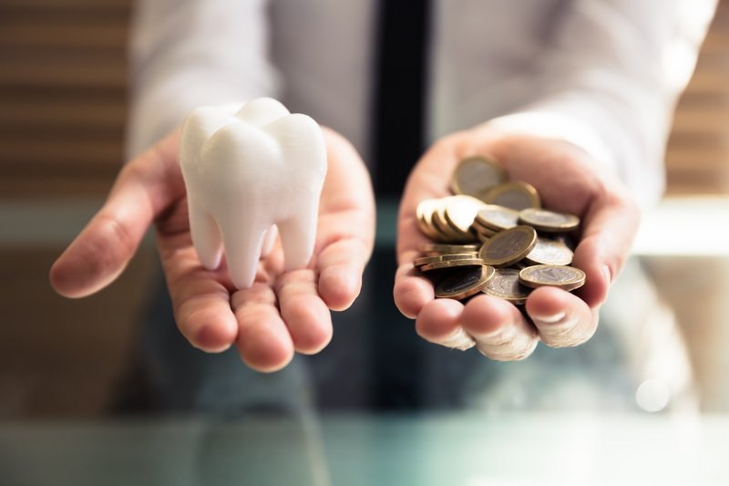 Person holding tooth in one hand and coins in the other