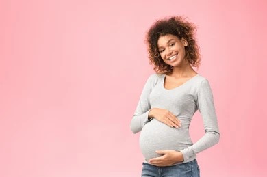 pregnant person holding stomach and smiling