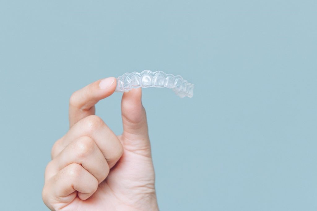 person holding clear aligner tray